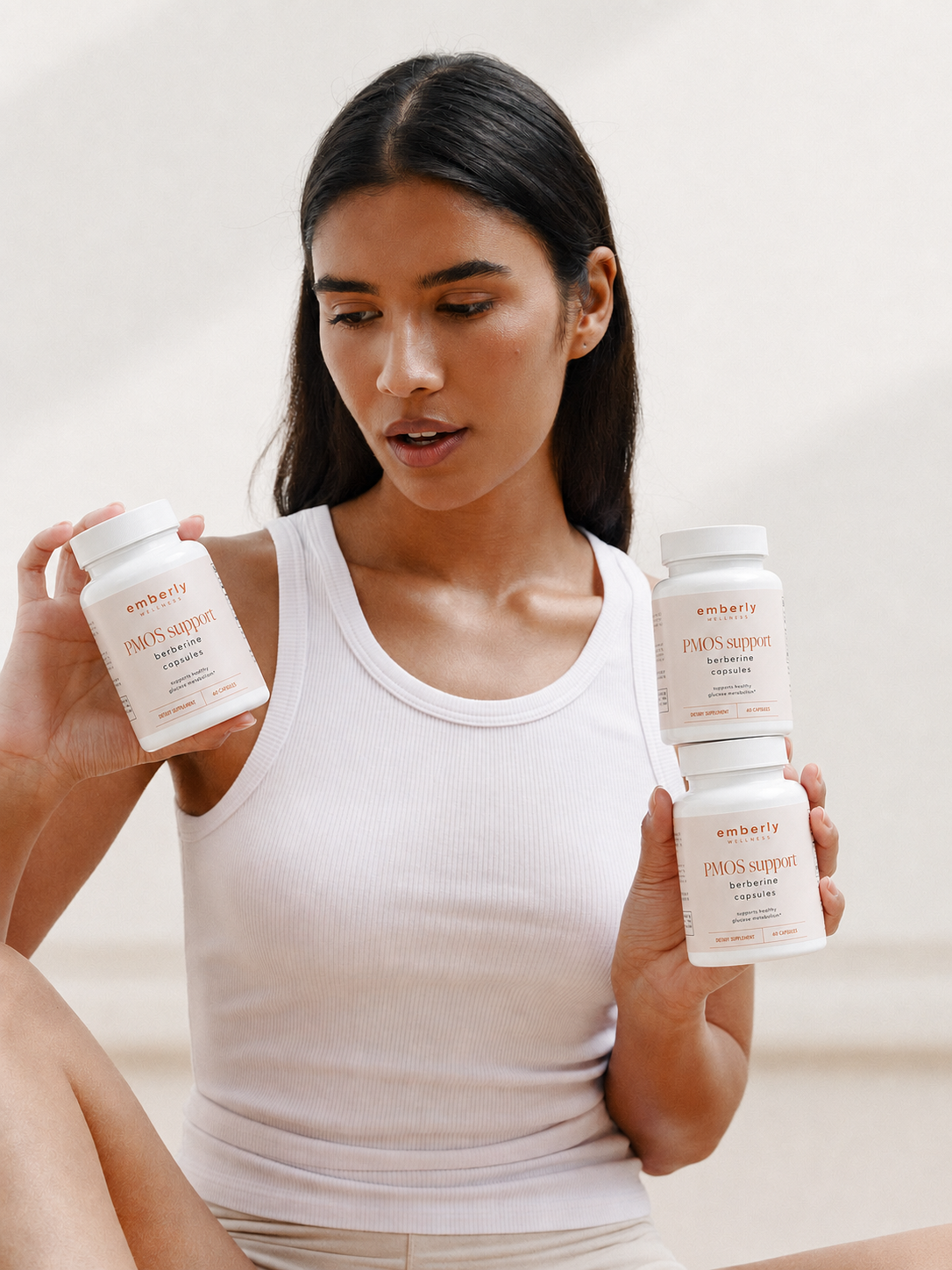 Woman holding emberly PMOS Support berberine bottles
